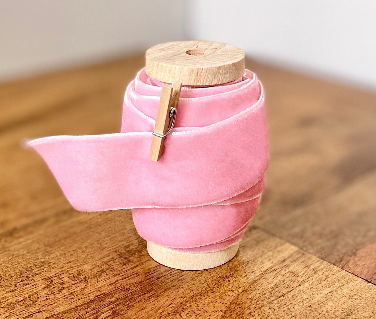 Pink velvet ribbon, 1 inch wide, on wooden spool