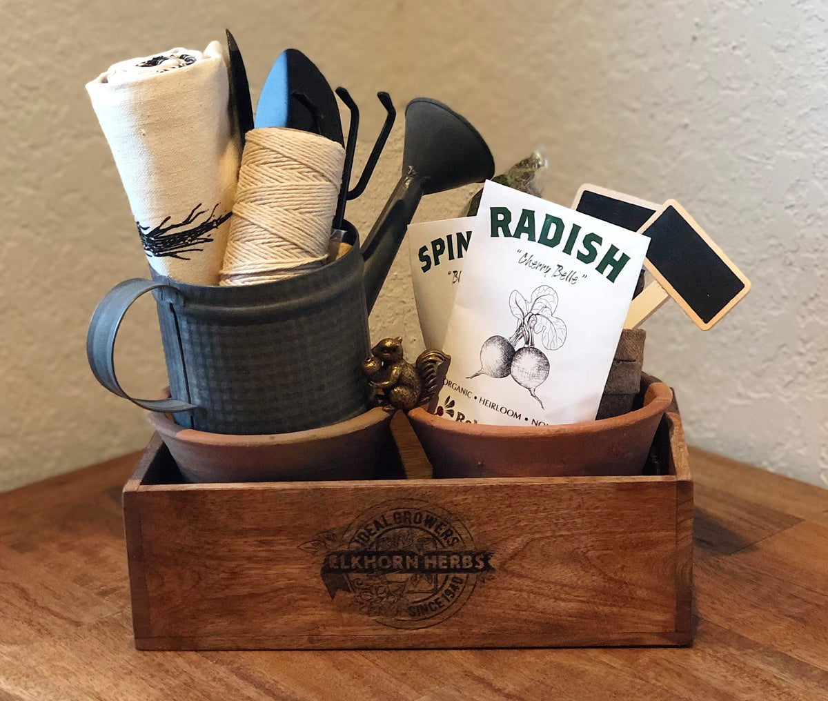 Rustic Herb Garden Starter Kit in vintage wooden crate with watering can, seed packets, twine, and garden tools