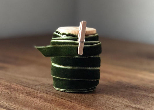 Emerald olive green velvet ribbon on wooden spool