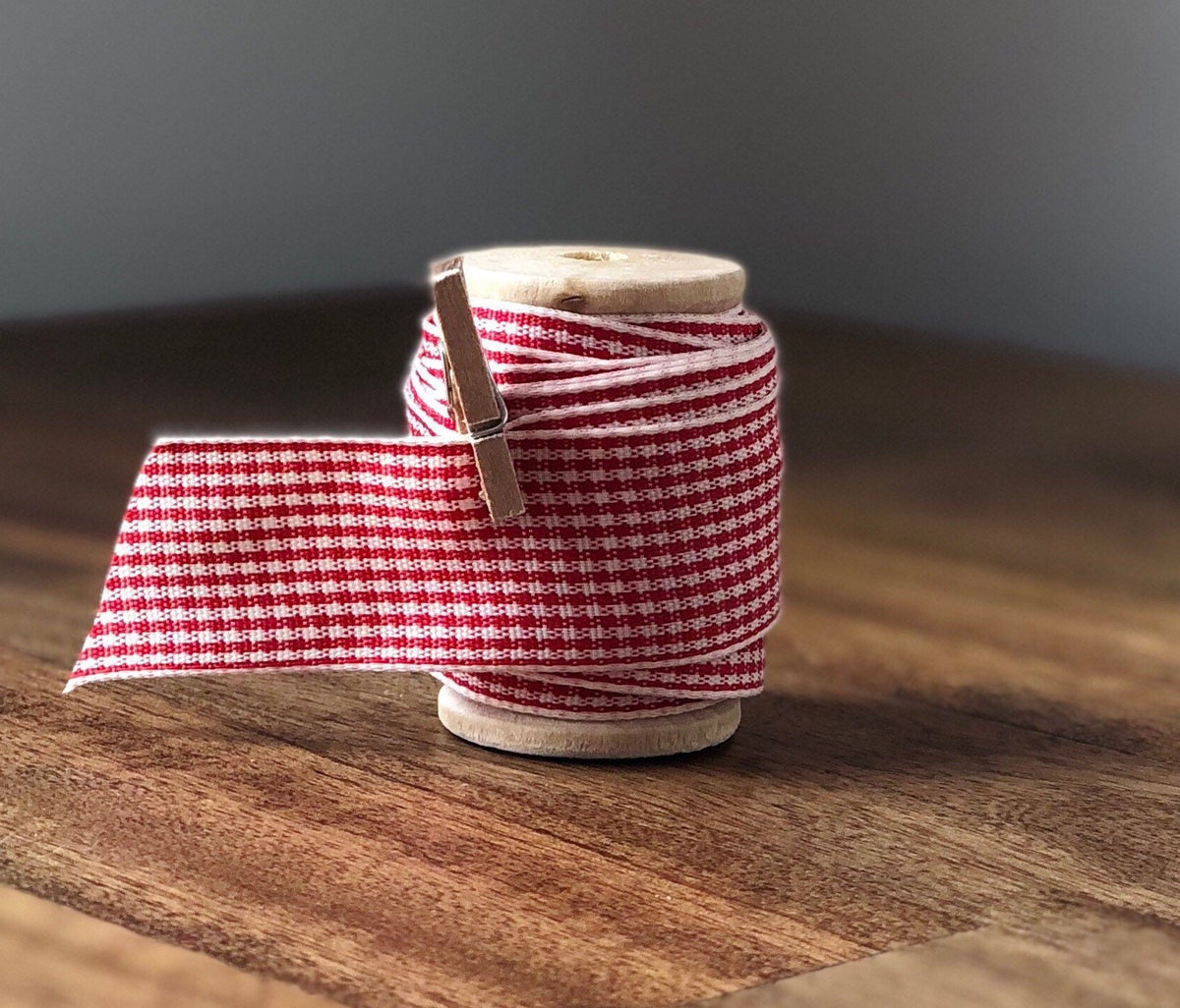 Red and cream plaid satin ribbon on wooden spool