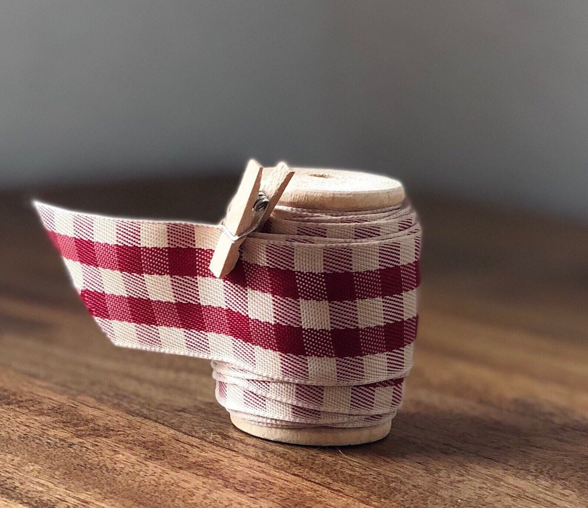 Red and cream gingham satin ribbon on wooden spool