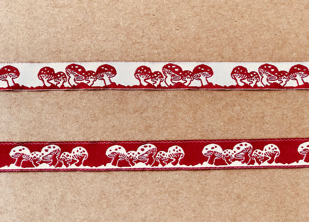 Embroidered red and white mushroom ribbon on wooden spool, view 2