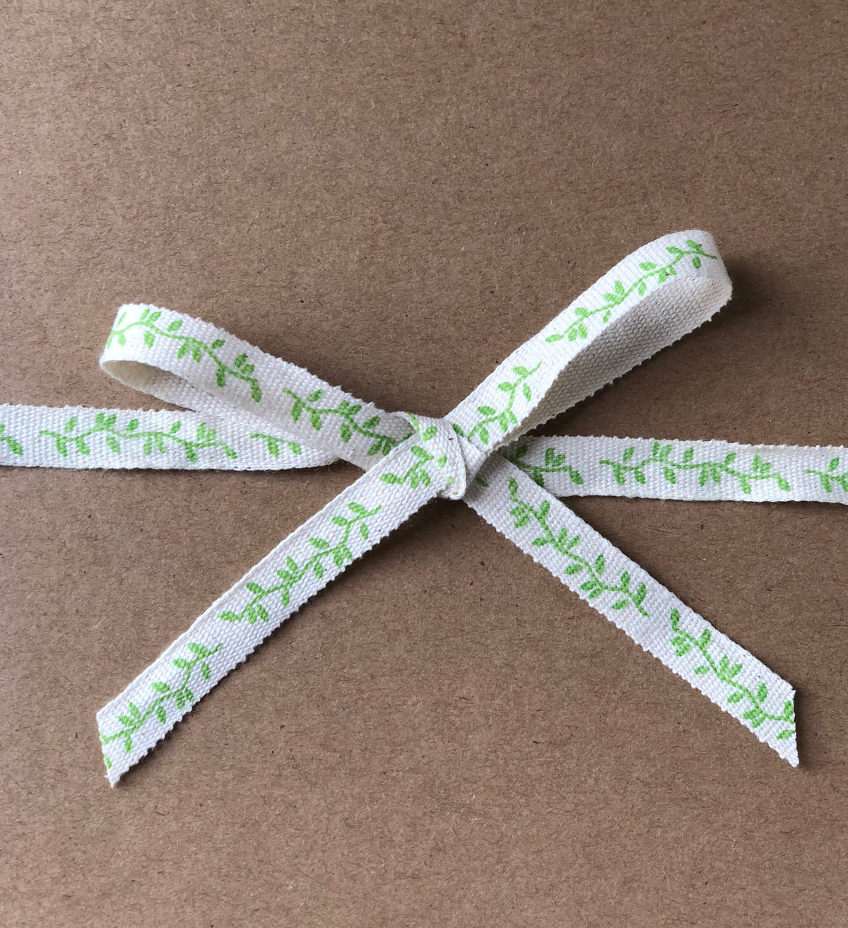 Green leaf print cotton ribbon on wooden spool, view 3