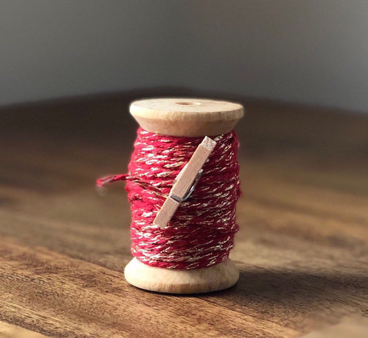 Red and gold glitter twine on wooden spool