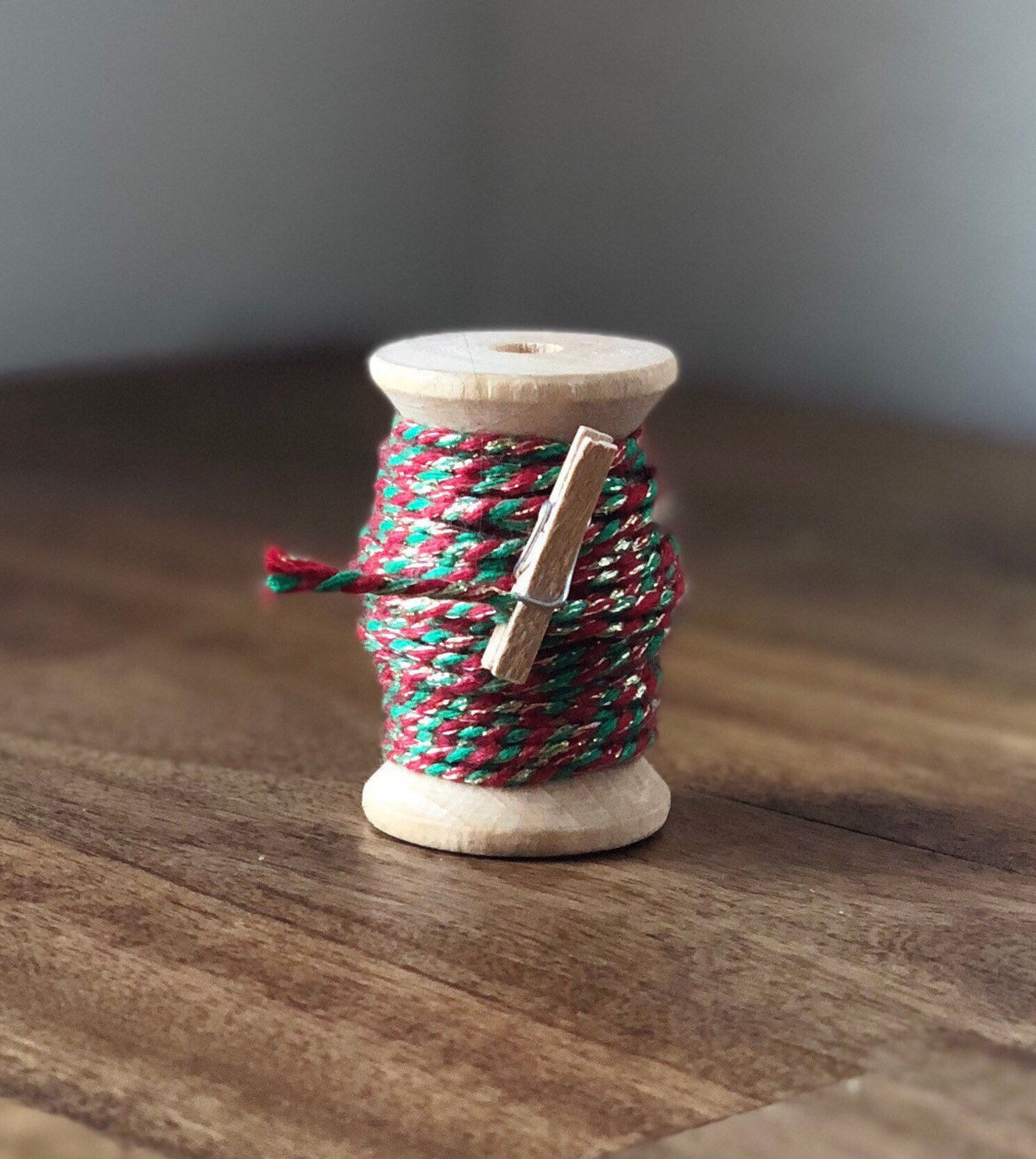 Red, green and gold glitter twine on wooden spool