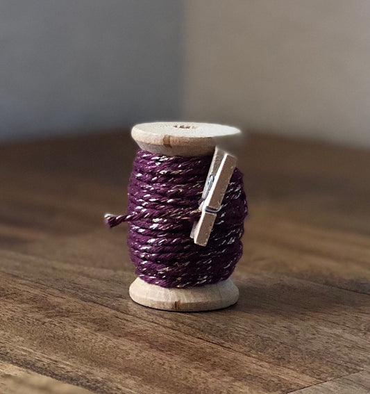Burgundy and gold glitter twine on wooden spool