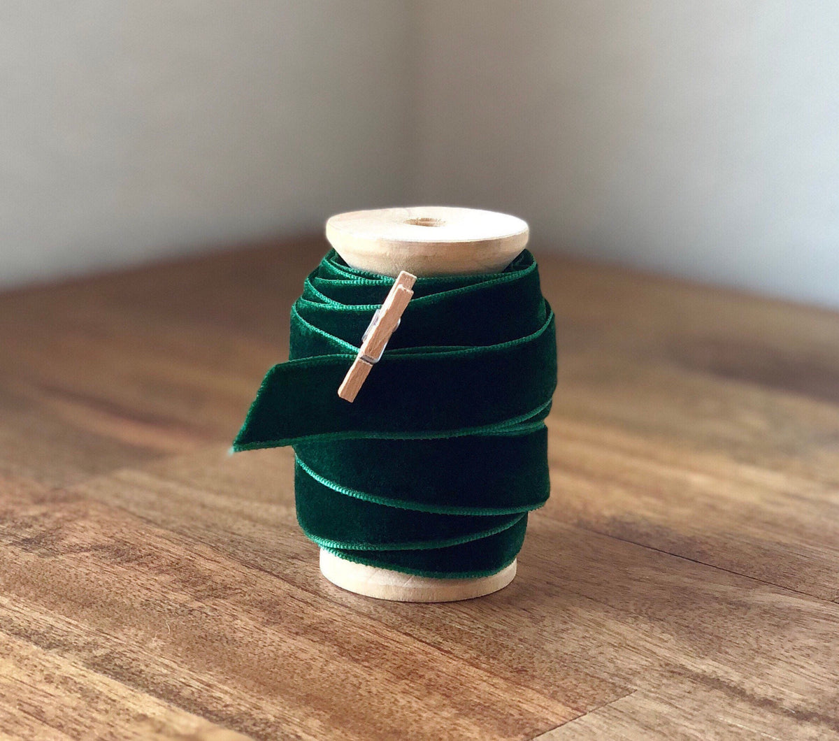 Emerald green velvet ribbon on large wooden spool