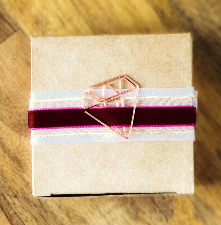 Blush pink organza ribbon with gold edge on wooden spool, view 2