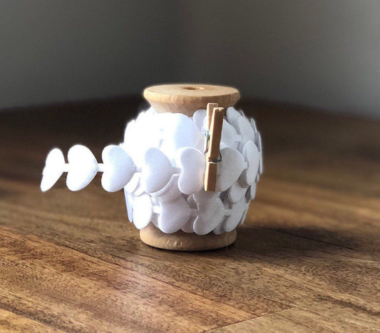 White satin heart ribbon on wooden spool