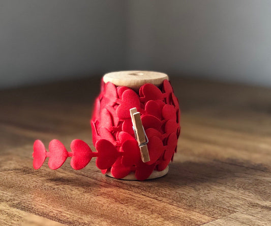 Red satin heart ribbon on wooden spool