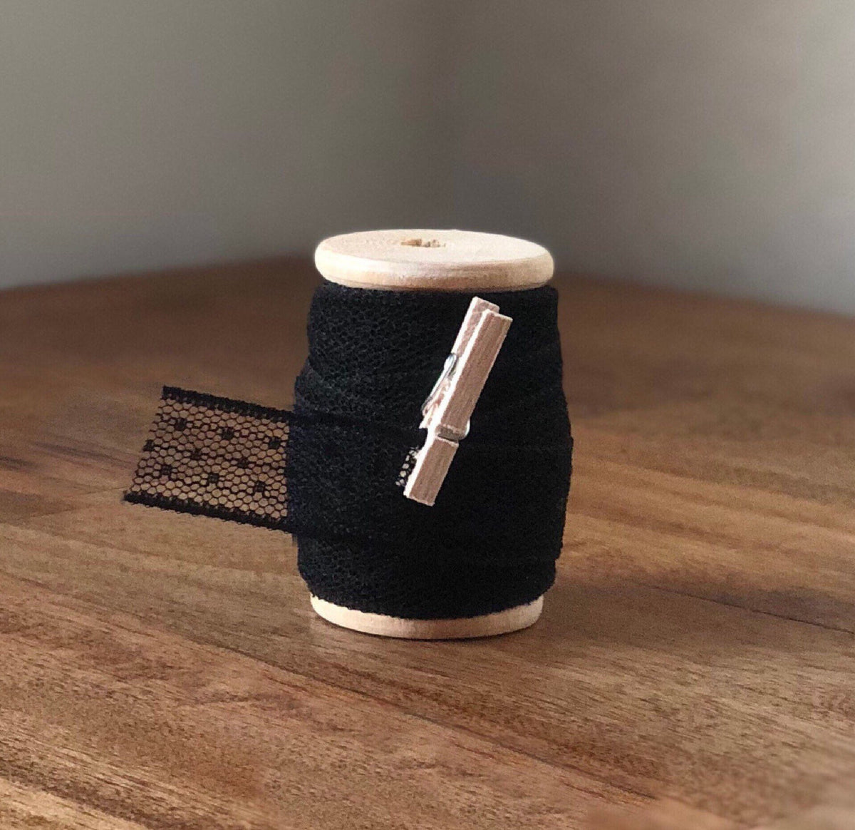 Black polka dot lace ribbon on wooden spool