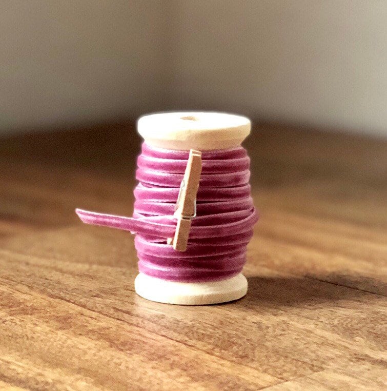 Thin lavender velvet ribbon on wooden spool