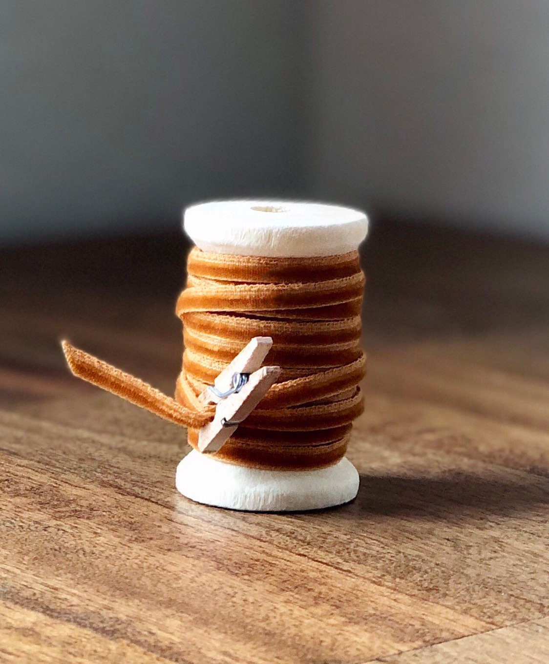 Thin burnt orange velvet ribbon on wooden spool