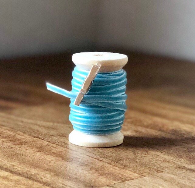 Thin baby blue velvet ribbon on wooden spool