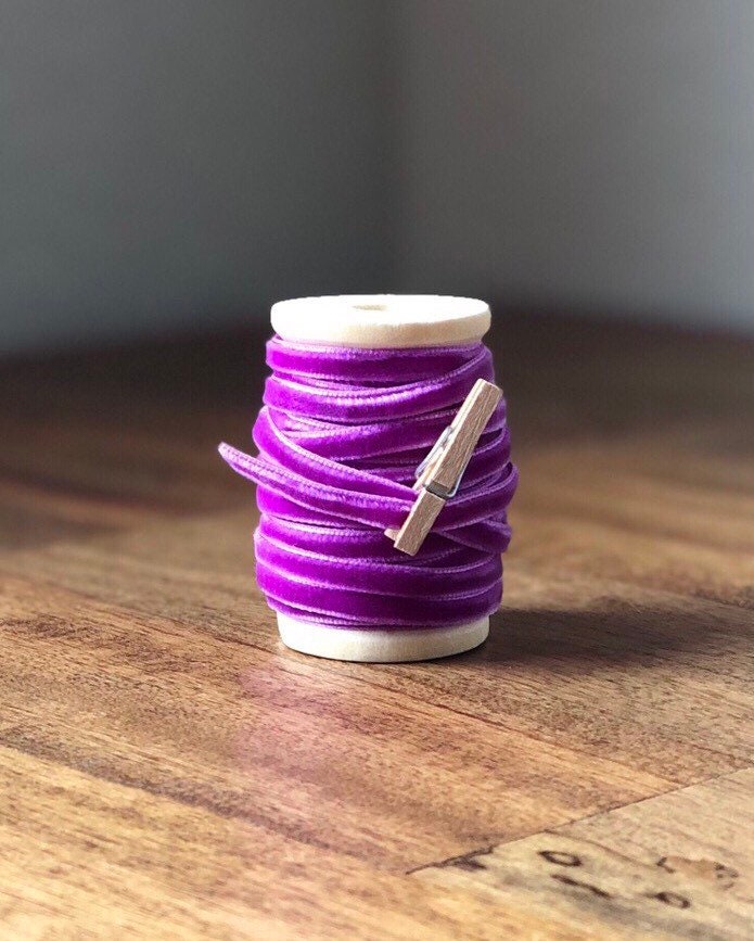 Thin purple velvet ribbon on wooden spool