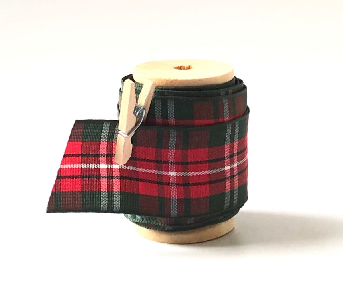 Red and green plaid Christmas satin ribbon on wooden spool