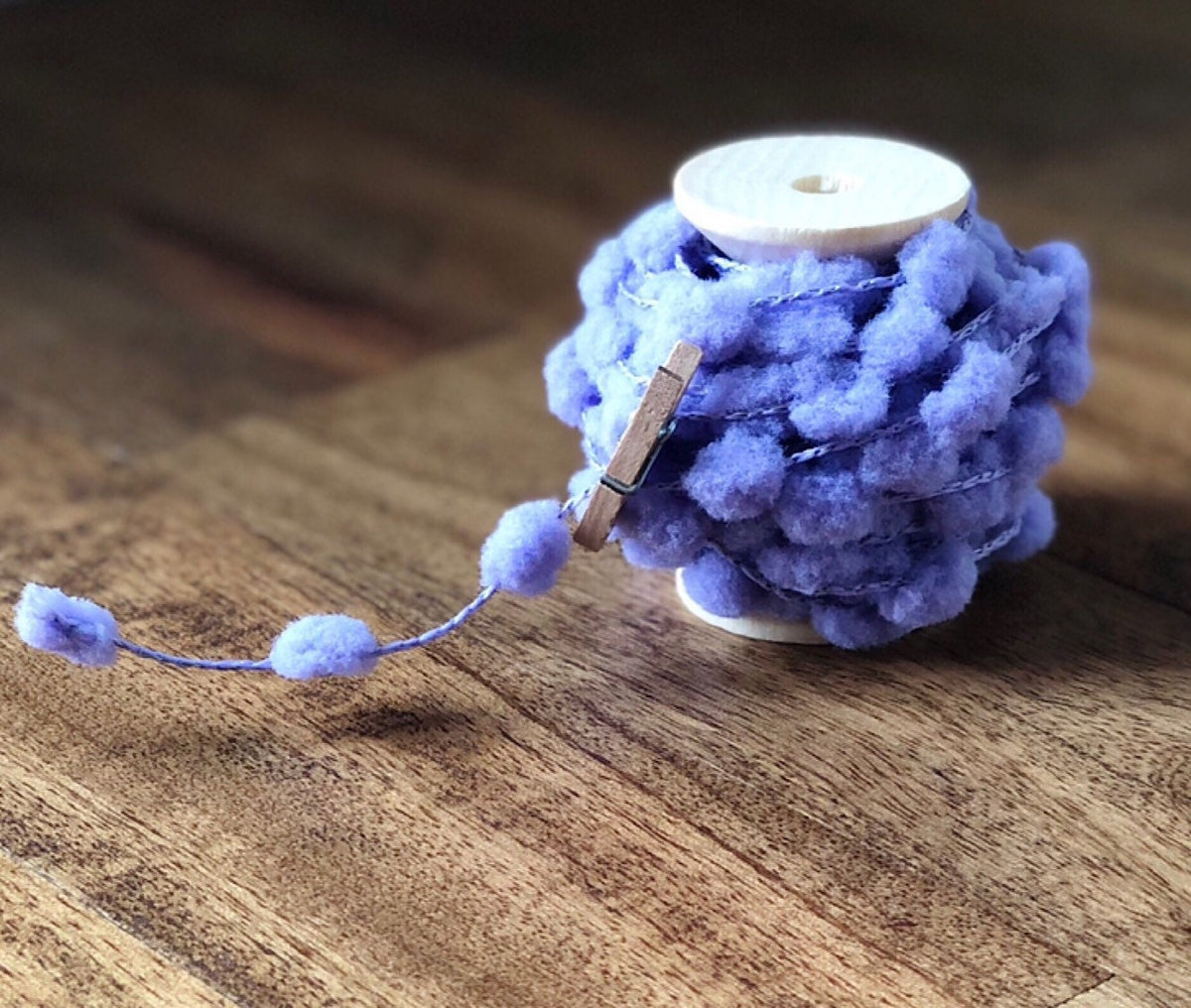 Wired pom pom ribbon trim on wooden spool, view 4
