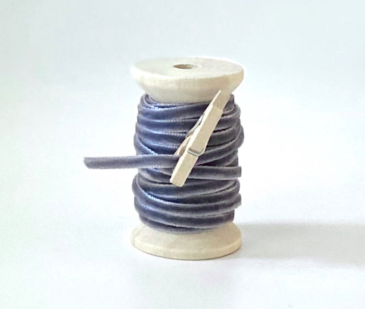 Thin gray velvet ribbon on wooden spool
